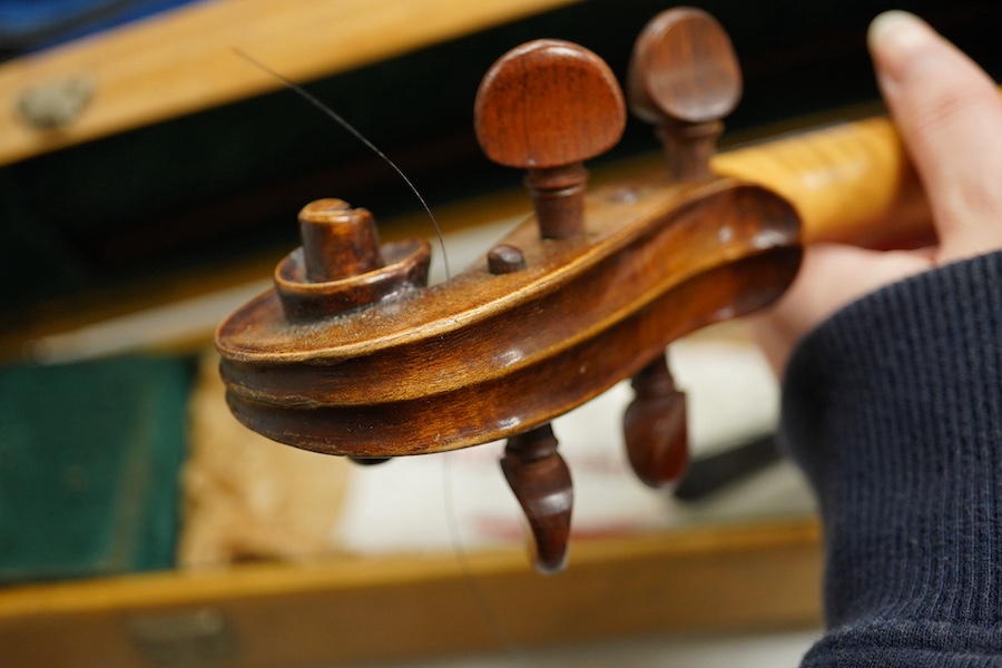 Four cased violins; an early 20th century violin, body 36cm, fitted with a microphone pick up taking a quarter inch jack plug, an early 20th century half size violin, body 32cm, and two student violins. Condition - poor